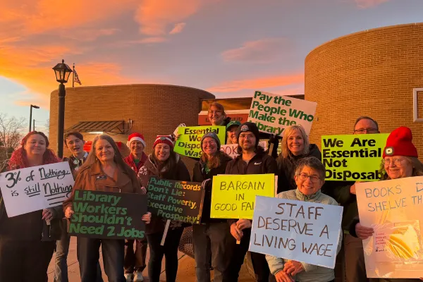 Union members holding signs standing outside of their workplace